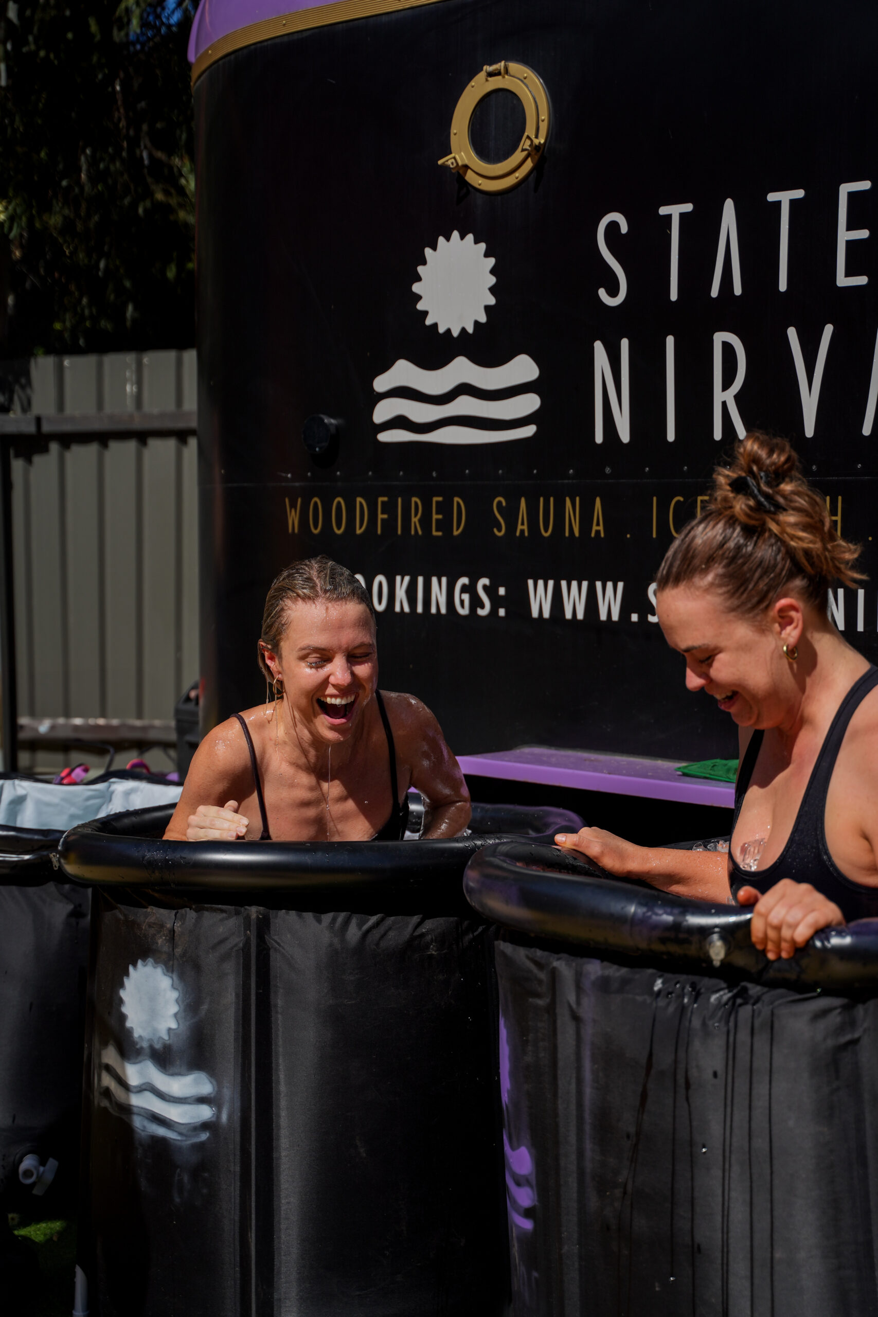 Two women plunging in an ice bath